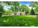 Spacious backyard featuring lush green lawn, mature trees, and a detached garage with basketball hoop at 1725 W 53Rd St, Indianapolis, IN 46228