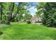 Spacious backyard with mature trees, lush green lawn, and a private setting at 1725 W 53Rd St, Indianapolis, IN 46228