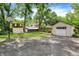 Spacious backyard featuring a storage shed, detached garage, and basketball hoop at 1725 W 53Rd St, Indianapolis, IN 46228