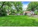 Expansive backyard featuring lush green grass, mature trees, and a detached garage at 1725 W 53Rd St, Indianapolis, IN 46228