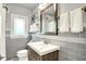 Stylish bathroom features a modern vanity, decorative tile backsplash, and a large framed mirror at 1725 W 53Rd St, Indianapolis, IN 46228