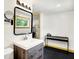 Bathroom with sleek modern vanity, mirror, ample lighting, and a glimpse into a closet in renovated space at 1725 W 53Rd St, Indianapolis, IN 46228