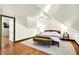 Attic bedroom space with a queen size bed, bedside tables with lamps, and an olive colored chaise lounge at 1725 W 53Rd St, Indianapolis, IN 46228
