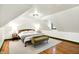 Cozy bedroom with a queen bed, bedside tables with lamps, and olive colored chaise lounge in an attic at 1725 W 53Rd St, Indianapolis, IN 46228