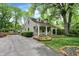 Charming home featuring a welcoming front porch, lush landscaping, and a spacious driveway at 1725 W 53Rd St, Indianapolis, IN 46228