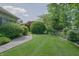 Expansive backyard with manicured lawn, mature trees, and winding stone pathway enhancing the property's appeal at 1858 Broadleaf Ct, Greenwood, IN 46143