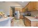 Well-lit kitchen with stainless steel appliances, wooden cabinets, and tile flooring at 1858 Broadleaf Ct, Greenwood, IN 46143
