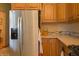 Bright kitchen featuring stainless steel refrigerator and wooden cabinets with stone countertops at 1858 Broadleaf Ct, Greenwood, IN 46143
