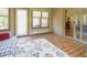 Bright sunroom with brick wall, wood floors, large rug, and sliding glass doors to living area at 1858 Broadleaf Ct, Greenwood, IN 46143