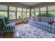 Sunroom is a sun-drenched space with a comfortable couch, floral rug and bright windows at 1858 Broadleaf Ct, Greenwood, IN 46143
