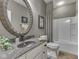 Bathroom featuring stone sink and framed mirror, with bathtub and patterned shower curtain at 187 N Bend Dr, Greenwood, IN 46142