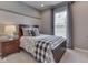 Bedroom with striped accent wall, a matching black-and-white bedspread and window with blinds at 187 N Bend Dr, Greenwood, IN 46142