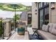 Relaxing balcony with outdoor seating, a green striped umbrella, and black metal railings at 1894 Rhettsbury St, Carmel, IN 46032