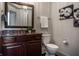 Elegant powder room featuring a dark wood vanity with marble countertop, complemented by modern fixtures and tasteful decor at 1894 Rhettsbury St, Carmel, IN 46032