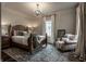 Comfortable bedroom with a wooden bed frame, patterned rug, and a cozy armchair at 1894 Rhettsbury St, Carmel, IN 46032