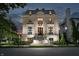 Elegant stone home with meticulous landscaping and a grand entrance at twilight at 1894 Rhettsbury St, Carmel, IN 46032