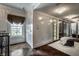 Hallway leading to a walk-in closet with herringbone wood floors, natural light, and a decorative chandelier at 1894 Rhettsbury St, Carmel, IN 46032
