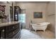 Bright bathroom with a clawfoot tub, stylish vanity, and dark wood cabinet at 1894 Rhettsbury St, Carmel, IN 46032