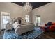 Luxurious main bedroom with a crystal chandelier, blue patterned rug, and bright red chair at 1894 Rhettsbury St, Carmel, IN 46032