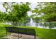 Scenic view of a pond with a water fountain, surrounded by lush greenery and a park bench at 1894 Rhettsbury St, Carmel, IN 46032