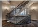 Grand staircase with wrought iron railing and wood flooring adds a touch of elegance to the home at 1894 Rhettsbury St, Carmel, IN 46032
