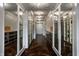 Spacious walk-in closet with custom shelving, mirrored cabinets and hardwood flooring creating an organized and luxurious space at 1894 Rhettsbury St, Carmel, IN 46032
