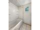 Small bathroom featuring a white tub, shower, shelving and a window, ready for restoration at 1947 N Parker Ave, Indianapolis, IN 46218
