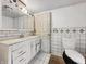 Compact bathroom featuring a vanity with mirror, toilet, and tiled walls, ready for remodeling at 1947 N Parker Ave, Indianapolis, IN 46218