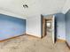 Bedroom with stained carpet and painted blue walls in need of repair at 1947 N Parker Ave, Indianapolis, IN 46218