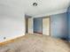 Bedroom with carpet and blue walls with trim around doors in need of repair at 1947 N Parker Ave, Indianapolis, IN 46218
