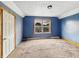 Bedroom with carpet, window and painted blue walls in need of repair at 1947 N Parker Ave, Indianapolis, IN 46218