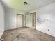 Unfurnished bedroom with stained carpet and multiple doors and walls in need of repair at 1947 N Parker Ave, Indianapolis, IN 46218