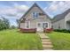 Modest two-story home featuring vinyl siding, brick accents, and a well-maintained lawn at 1947 N Parker Ave, Indianapolis, IN 46218
