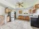 A kitchen features tile floors, wood cabinets, an updated refrigerator, and natural light, awaiting your personal touch at 1947 N Parker Ave, Indianapolis, IN 46218