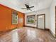 Bright living room featuring hardwood floors, natural light, and orange accent wall at 1947 N Parker Ave, Indianapolis, IN 46218