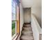 Carpeted stairway leading to upper level, bathed in natural light from a nearby window at 1947 N Parker Ave, Indianapolis, IN 46218