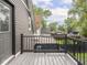 View of back deck with black metal railing, wood floor, and view of the neighboring houses at 2222 Pleasant St, Indianapolis, IN 46203