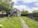 Charming backyard featuring an accessory dwelling unit (ADU), stone path, and mature trees at 2222 Pleasant St, Indianapolis, IN 46203