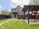 Green backyard with wooden pergola, swing chair, fire pit, and sliding glass doors at 2222 Pleasant St, Indianapolis, IN 46203