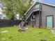 A fenced backyard with green grass and a fire pit next to the gray home at 2222 Pleasant St, Indianapolis, IN 46203