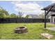 Spacious backyard with green grass, brick fire pit, and a tall wooden fence at 2222 Pleasant St, Indianapolis, IN 46203