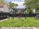 Fenced backyard with wooden pergola, red swing chair, and green grass at 2222 Pleasant St, Indianapolis, IN 46203