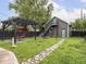 Backyard featuring an accessory dwelling unit (ADU), stone path, mature trees, and a pergola at 2222 Pleasant St, Indianapolis, IN 46203