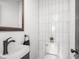Modern powder room features a wall-mounted sink and a beautifully tiled accent wall behind the toilet at 2222 Pleasant St, Indianapolis, IN 46203