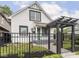 Charming white home features a black metal fence, dark-trimmed windows and a lovely pergola entrance at 2222 Pleasant St, Indianapolis, IN 46203
