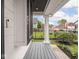Inviting front porch featuring classic white columns, gray wood decking and manicured garden at 2222 Pleasant St, Indianapolis, IN 46203