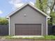 A gray garage with brown garage door is in the backyard of this home at 2222 Pleasant St, Indianapolis, IN 46203