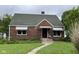 Charming brick home featuring a peaked roof, awnings, and a small front garden with a traditional-style entrance at 230 E Poplar St, Danville, IN 46122