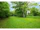 Lush green backyard with mature trees providing shade and privacy at 2402 Adams St, Indianapolis, IN 46218