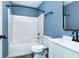 Bathroom featuring a white bathtub, toilet, and vanity against calming blue walls at 2402 Adams St, Indianapolis, IN 46218